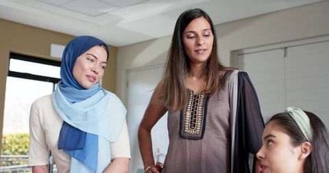 Diverse women collaborating in modern office wearing hijab and contemporary ethnic attire