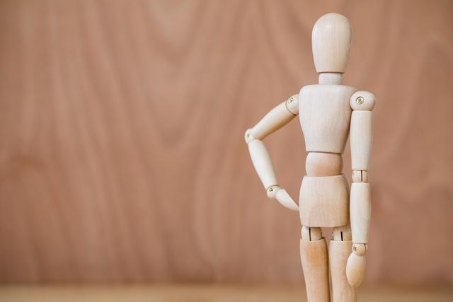 Conceptual image of figurine standing with hands on hip on a wooden floor