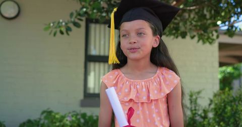 African american girl wearing graduation cap holding diploma celebrating school milestone