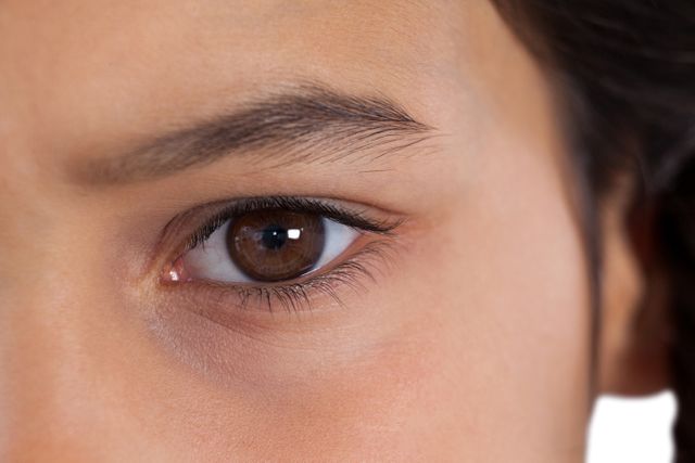 Close-up of a young girl's eye with a focus on the eyebrow and eyelashes. Ideal for use in beauty, healthcare, and educational materials. Can be used to illustrate concepts of vision, eye care, and facial features.