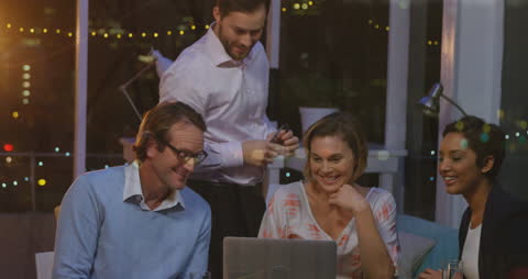 Business Team Analyzing Financial Data with Laptops in Evening Office