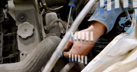 Tightening engine bolt with screwdriver, mechanic hand repairing car, data overlay