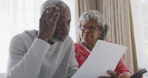 Senior couple reviewing paperwork together at home