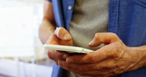Middle-Aged Man Engaging with Smartphone in Minimalistic Setting