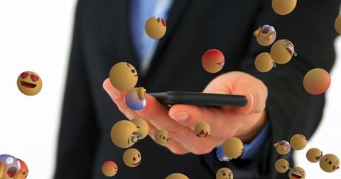 Businessman interacting with emoji on smartphone screen