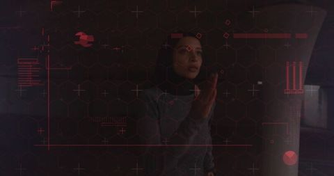 Muslim woman in hijab interacting with red holographic hud for futuristic tech concept