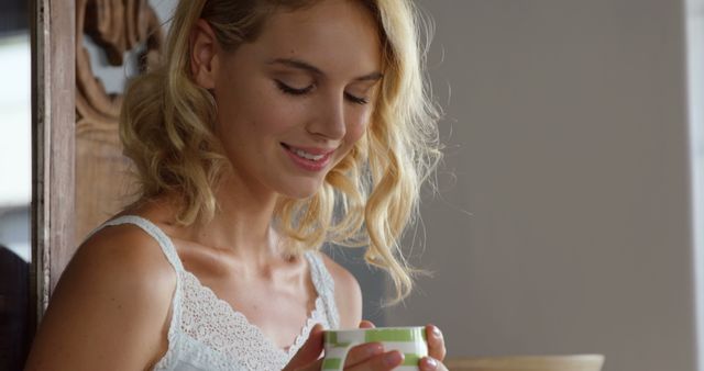 Smiling Woman Enjoying a Cup of Tea in Bright Room - Download Free Stock Images Pikwizard.com