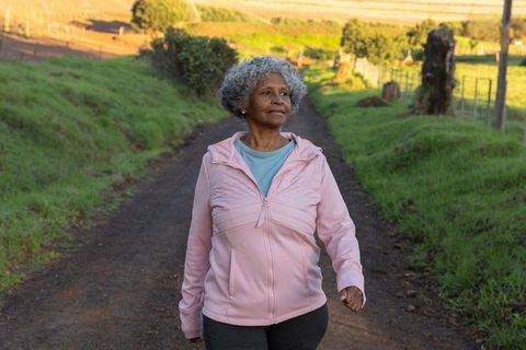 Senior woman enjoying walk in scenic countryside
