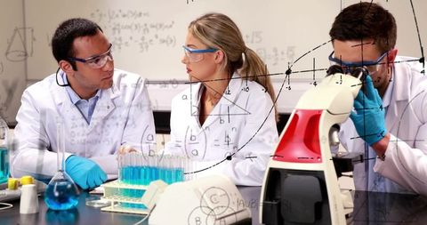 Laboratory team discussing experiments with microscope and blue test tubes, teamwork