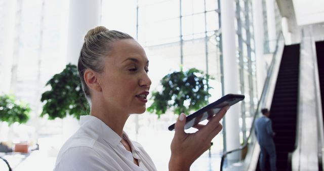 Businesswoman Using Smartphone Voice Command in Modern Office - Download Free Stock Images Pikwizard.com