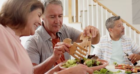 Senior Friends Enjoying Leisurely Meal Together at Home