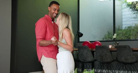 Happy Interracial Couple Dancing in Modern Living Room
