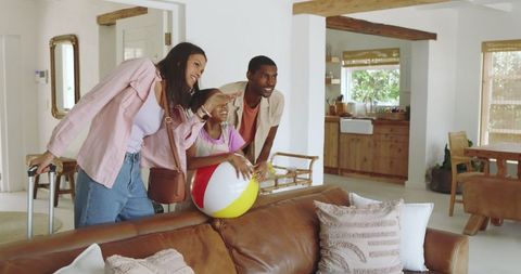 Excited family preparing for trip with luggage and beach ball