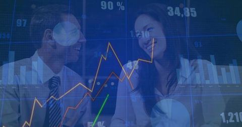 Colleagues analyzing charts on transparent display in modern boardroom
