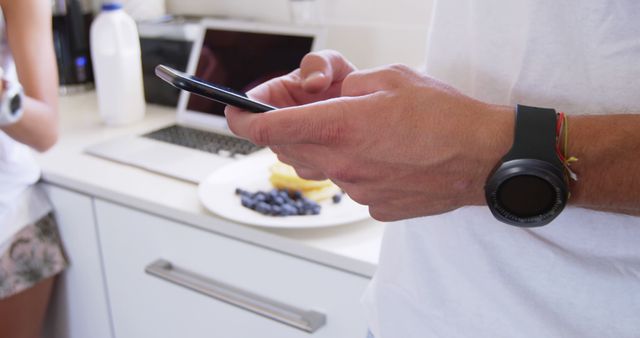 Close-up of man using smartphone in kitchen - Download Free Stock Images Pikwizard.com