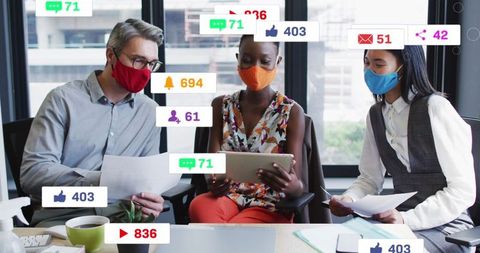 Masked Colleagues Discussing Social Media Analytics in Modern Office