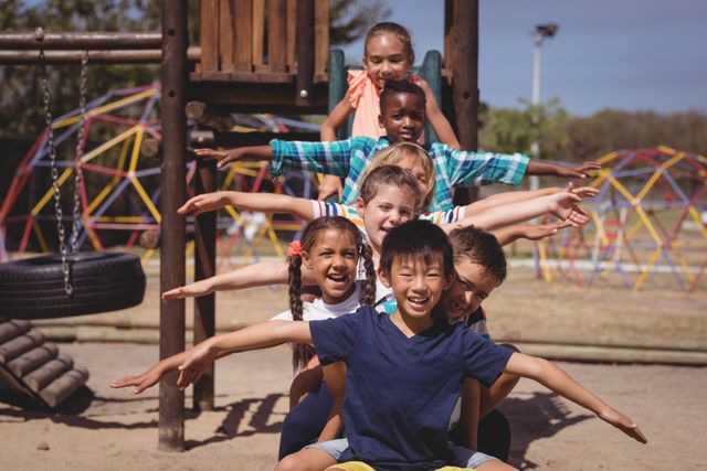 Group of happy schoolchildren playing together in a playground, showing teamwork and joy. Ideal for use in educational materials, advertisements for children's products, community events, and articles about childhood development and outdoor activities.