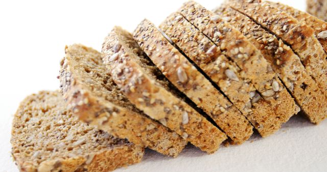 Sliced multigrain bread is arranged in a row, showcasing its texture and seeds, with copy space. Its wholesome ingredients highlight the focus on healthy eating and nutritious food choices.