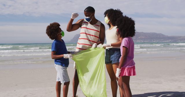 Family with children participating in beach clean-up, wearing face masks and gloves, collecting trash in green bag. Promotes community service, teamwork, environmental responsibility, and parenting. Suitable for articles and campaigns on sustainability, pollution, family activities, and volunteer work.