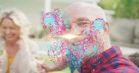 Smiling bald bearded man in plaid celebrating backyard pool party with colorful particles