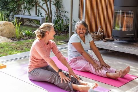 Senior women enjoying relaxing stretch outdoors on colorful yoga mats