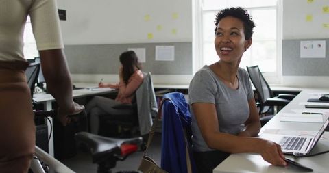 Smiling Businesswoman Greeting Colleague in Modern Office