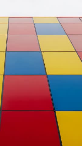 Tilting upward revealing colorful facade panels forming bold geometric grid pattern in vertical vide
