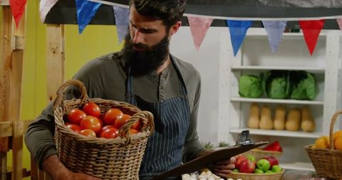 Bearded Vendor Organizing Fresh Harvest at Marketplace Stall