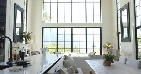 Sunlit Contemporary Farmhouse Interior with Black Grid Window Wall and Bright Open Kitchen Island