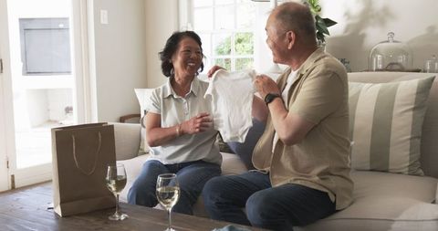 Elderly couple celebrating with a gift at home