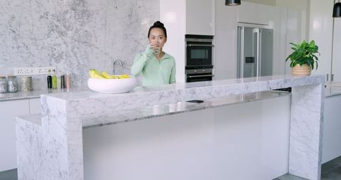 Modern Kitchen with Woman Drinking Water
