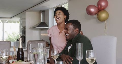 African American Friends Enjoying Wine and Laughter at Home Gathering
