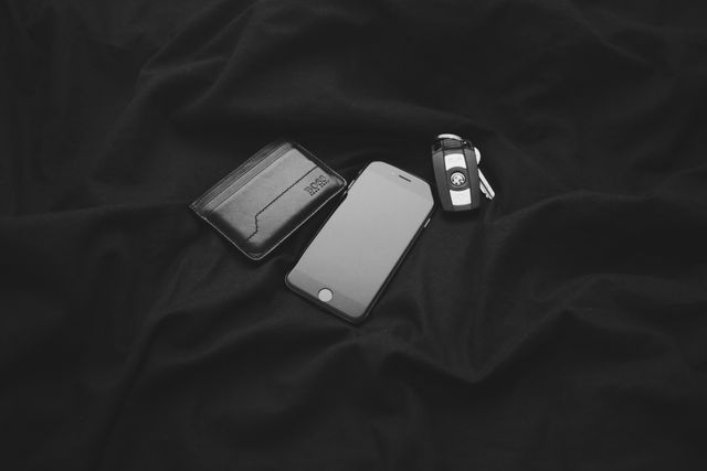 Perfect for illustrating minimalism and everyday carry items. Useful for lifestyle blogs, technology reviews, and articles related to productivity and organization. The image's monochrome theme adds a sleek and professional touch, making it fit well in business and tech-related contexts.