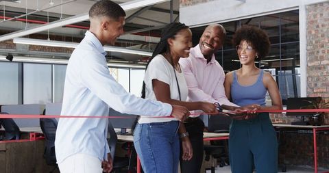 Team celebrating office opening with ribbon cutting ceremony