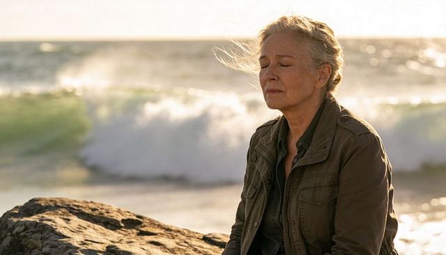 Senior woman finding calm on rocky coastline during golden hour