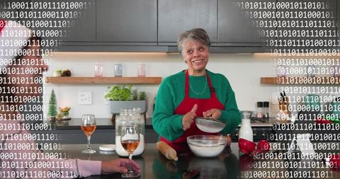 Senior woman sifting flour in modern kitchen, smiling while baking family dessert