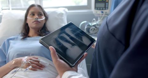 Female Patient and Doctor Discussing X-Ray in Hospital Room