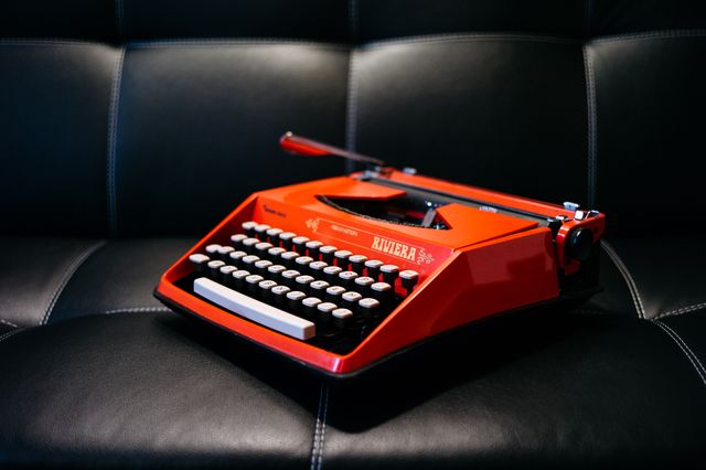 Vintage Red Typewriter on Black Leather Sofa - Download Free Stock Photos Pikwizard.com