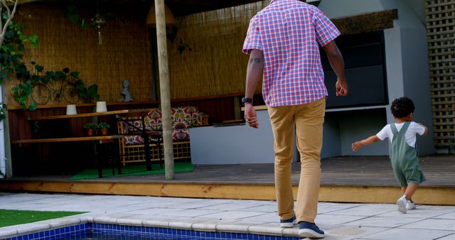 Father and toddler walking by poolside in backyard - Download Free Stock Images Pikwizard.com