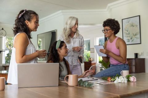 Diverse women collaborating on creative planning and brainstorming around sunlit home table
