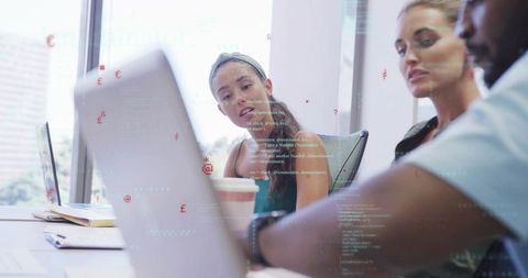 Collaborative team analyzing financial data on laptop with code and analytics overlay