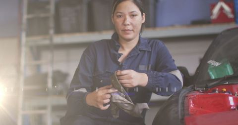 Female Mechanic in Workshop Holding Gloves Near Car - Download Free Stock Images Pikwizard.com