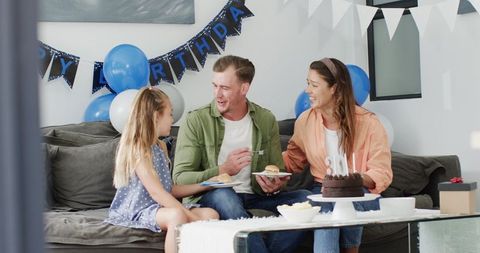 Family Celebrating Father's Birthday with Cake at Home