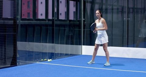 Focused Woman Ready for Padel Match on Modern Blue Court
