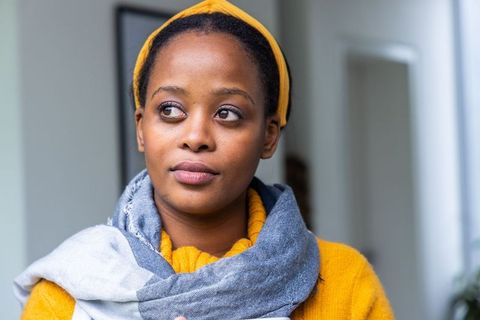 Contemplative african american woman wearing mustard sweater and grey-blue scarf