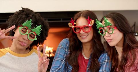 Friends Enjoying Holiday Together with Festive Glasses by Fireplace