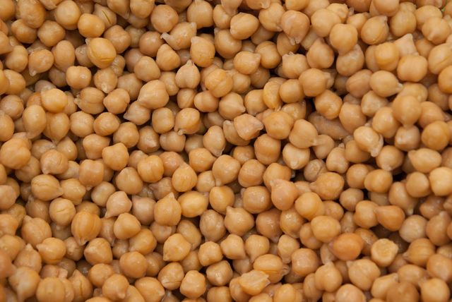 Close-up showing boiled chickpeas, showcasing their texture and color. This image is ideal for websites, blogs, and articles related to healthy eating, vegetarian diets, protein sources, or cooking recipes. Great for use as a background image for food-related content.