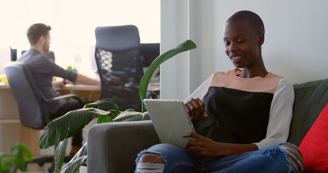 Smiling Woman Using Tablet on Couch in Modern Office - Download Free Stock Images Pikwizard.com