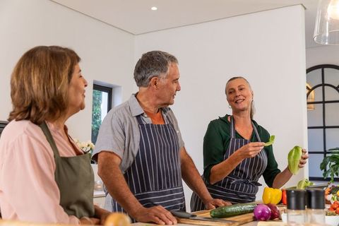 Senior Friends Joyfully Preparing Meal Together in Spacious Kitchen