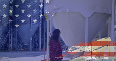 Woman Using Digital Tablet at Industrial Facility with American Flag Overlay